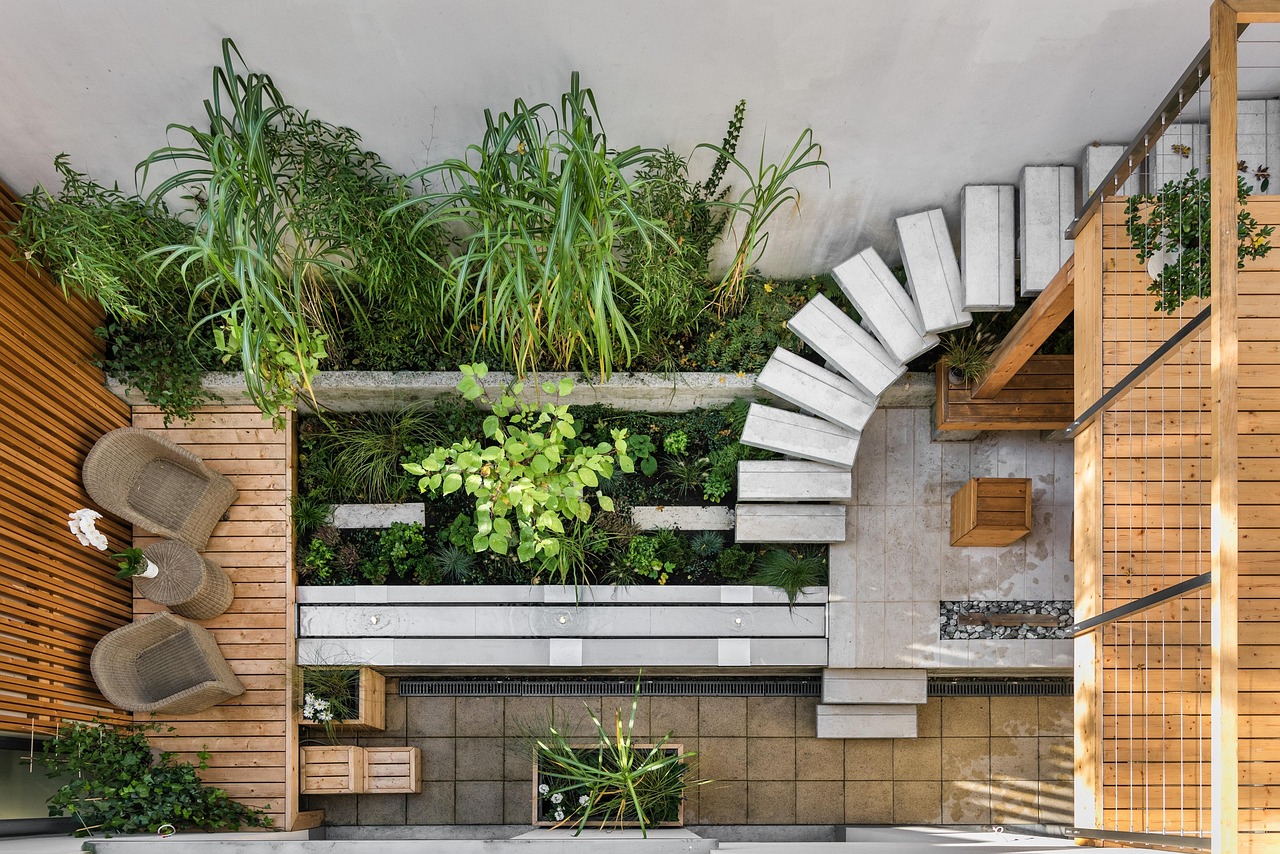 Jardin aménagé avec terrasse en bois et végétation, exemple de conception paysagère